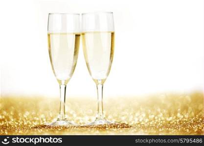 Pair of champagne flutes on shiny glitter background. Pair of champagne flutes