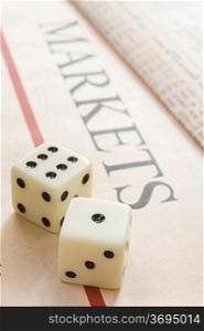 pair of dice resting on a paper with the headline Maekets