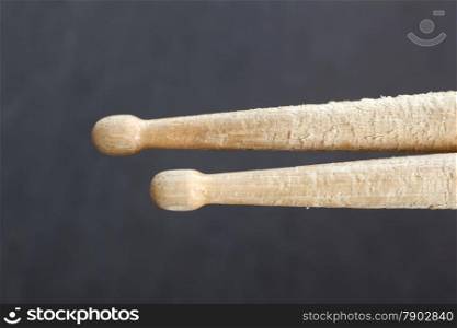 pair of drumsticks parallel against dark blue background