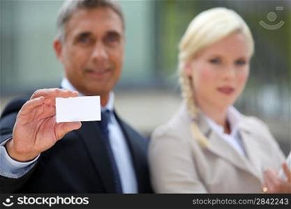 Pair of executives holding up a blank business card