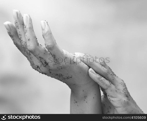 pair of hands rubbing exfoliator in during a beauty treatment