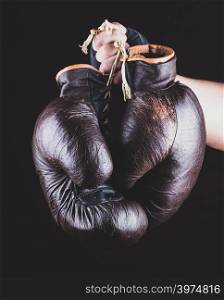 pair of leather sports boxing gloves in hand, vintage toning