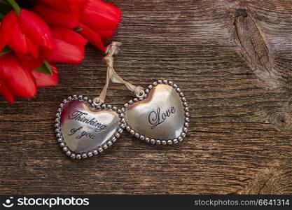 Pair of Lover hearts with red tulip flowers on wood. Love hearts with flowers