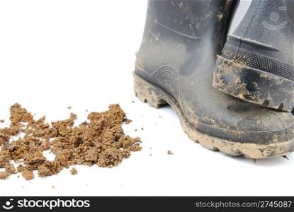 pair of muddy farmer boots isolated on a white background