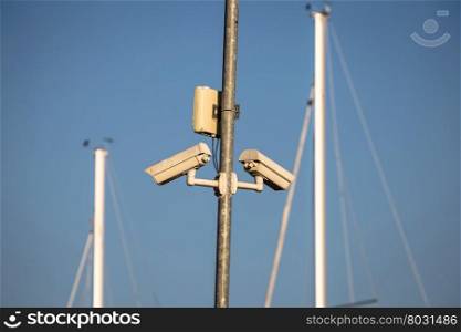 Pair of outdoor security cameras in yachting harbor