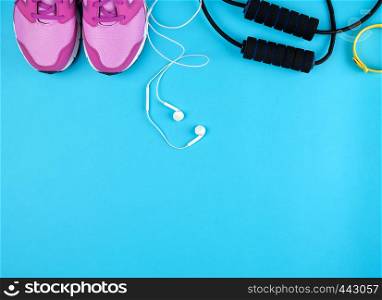 pair of pink sneakers with laces on a blue background, top view, copy space