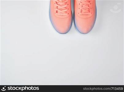 pair of pink sneakers with laces on a white background, top view, copy space