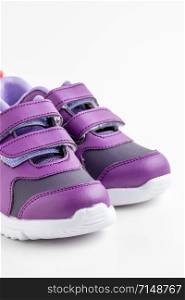 Pair of purple leather sport shoes for girls on white background. purple sport shoes