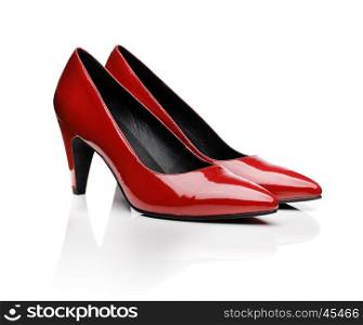 Pair of red women's pumps on white with natural reflection.