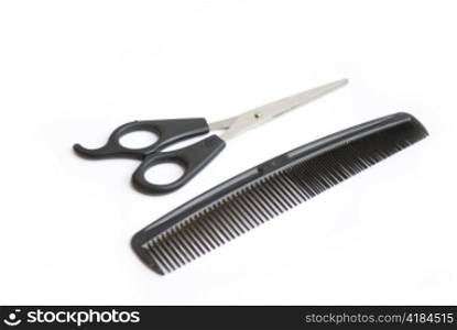 pair of scissors and comb isolated on white background