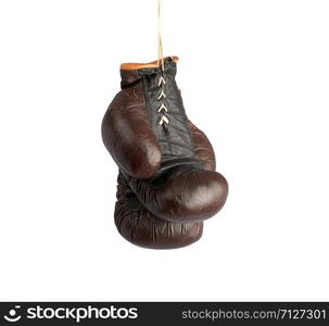 pair of very old vintage brown leather boxing gloves hanging on a rope, object isolated