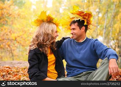 Pair with maple leaves looking each other in autumn wood