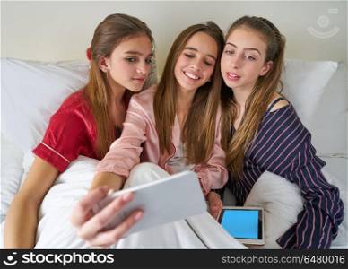 Pajama party best friend girls selfie at bed. Pajama party best friend girls selfie at bed with tablet and smartphone