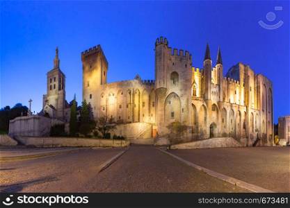 Palace of the Popes, once a fortress and palace, one of the largest and most important medieval Gothic buildings in Europe and Avignon Cathedral during evening blue hour, Avignon, southern France. Palace of the Popes, Avignon, France