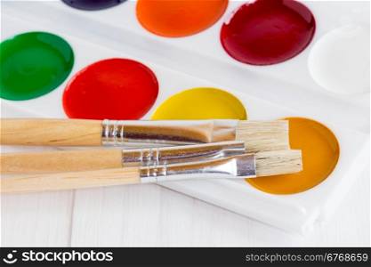 Palette of children&rsquo;s watercolor paints with paint brushes