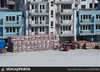 Pallets of bricks in front of new building. Horisontal image