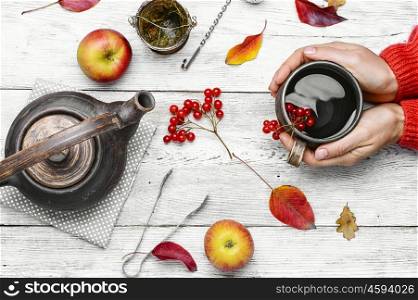 Palm of your hand with cup of autumn tea