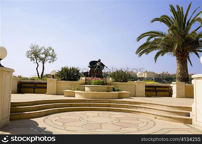 Palm tree and a statue in a garden, Monte Carlo, Monaco