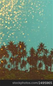 Palm trees on tropical beach, vintage toned and retro color stylized with golden shiny glitter bokeh background
