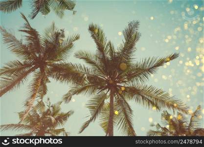 Palm trees retro color toned with shiny party bokeh glitter golden lights effect