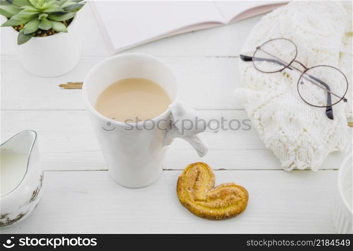 palmiers elephant ear puff pastry cookie with porcelain white tea cup wooden desk