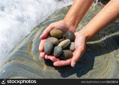 Palms hold a pile of stones on the seashore