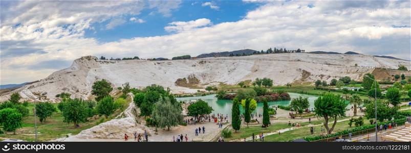 Pamukkale, Turkey ? 07.14.2019. White mountain and green lake in Pamukkale. Panoramic view from the side of the village on a cloudy summer evening.. Lake and mountain in Pamukkale Village, Turkey