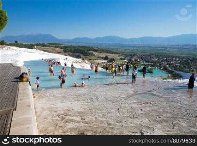 Pamukkale, Turkey - August, 14 2015: Tourists on Pamukkale Travertine pools and terraces. Pamukkale is famous UNESCO world heritage site in Turkey