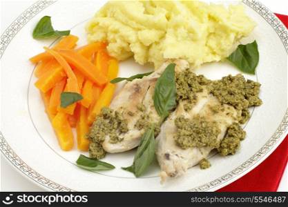 Pan fried chicken breasts served with pesto, julienned carrots, mashed potato and garnished with fresh basil leaves, a fusion of Italian and British cuisines. A very simple and delicious dish