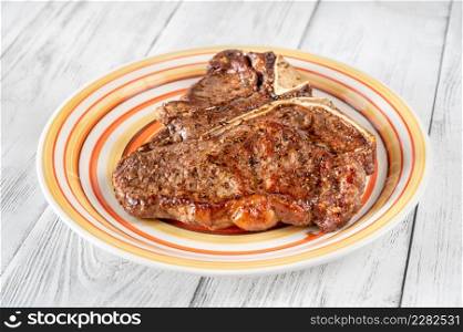 Pan-fried T-bone steak with pepper on the plate