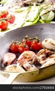 Pan with seafood and grilled tomatoes