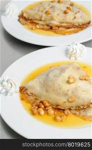 pancake crepe with peanuts and honey decorated with whipped cream. peanuts pancake crepe dessert