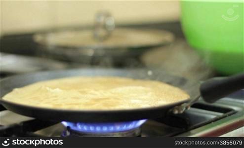 pancakes being made on pan in the kitchen.