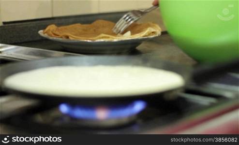 pancakes being made on pan in the kitchen.