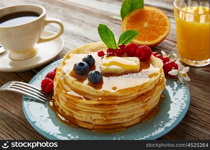 pancakes breakfast syrup coffee and orange juice with berries