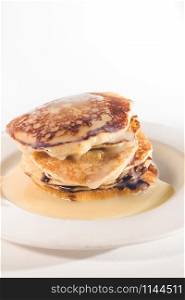 pancakes stacked on a white plate,Pancakes are topped with sweetened condensed milk.