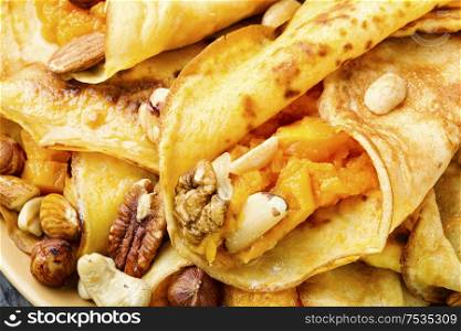 Pancakes stuffed with pumpkin and nut.Autumn food.Food background. Homemade pancakes with pumpkin