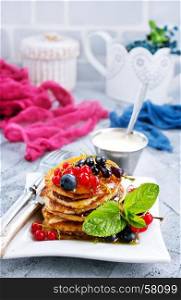 pancakes with berries on plate and on a table