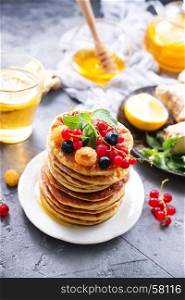 pancakes with berries on plate and on a table