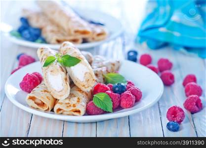 pancakes with berries on the white plate