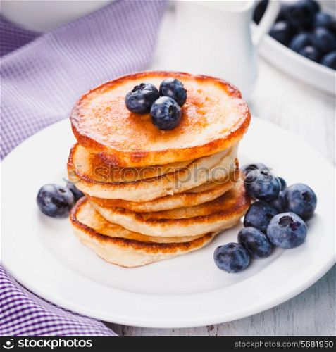 Pancakes with blueberry on a white plate and napkin
