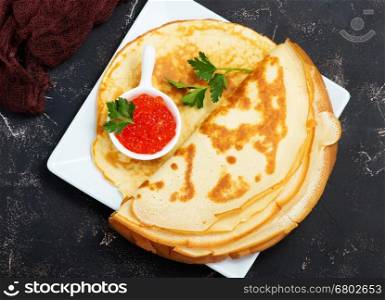 pancakes with caviar on the plate and on a table