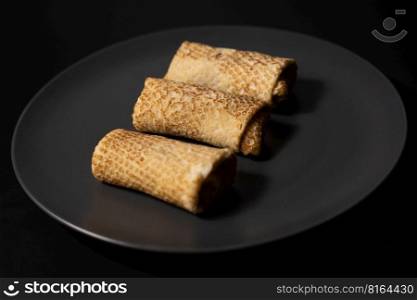 pancakes with cheese on a plate and kitchen utensils on a black background
