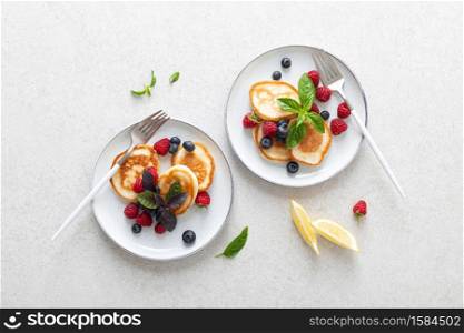 Pancakes with fresh blueberry and raspberry served for healthy vegetarian breakfast