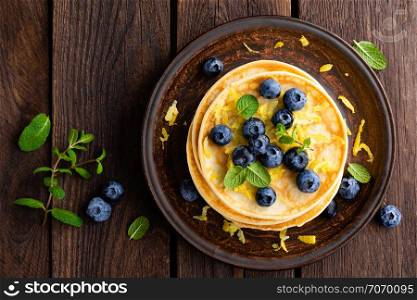 Pancakes with fresh blueberry on wooden rustic background. Top view