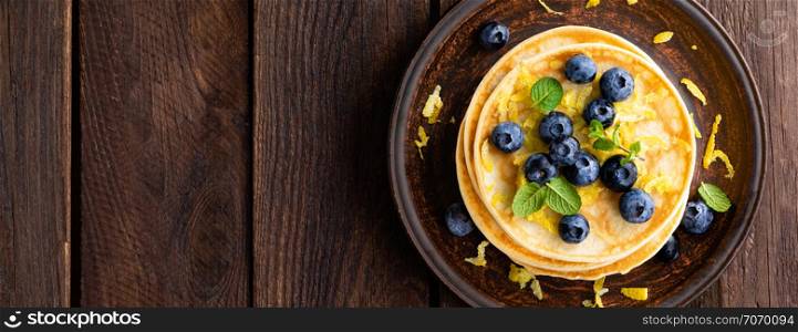 Pancakes with fresh blueberry on wooden rustic background. Top view. Banner