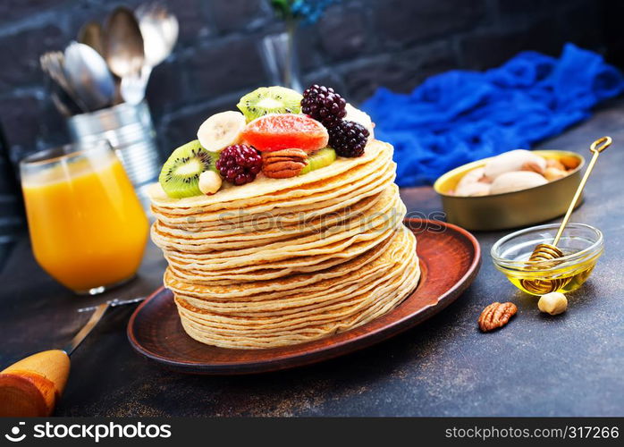 pancakes with fresh fruit and honey on plate