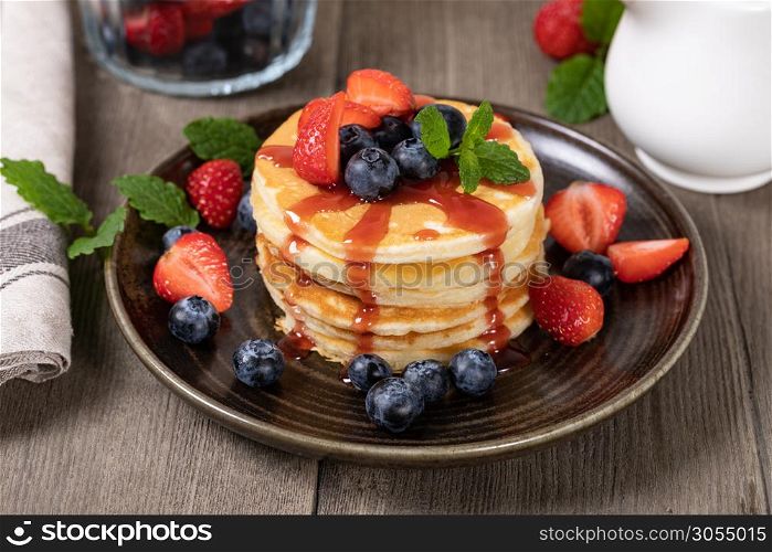 Pancakes with fresh strawberries, blueberries and syrup. Pancakes with fresh berry