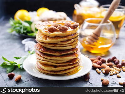 pancakes with honey on plate and on a table