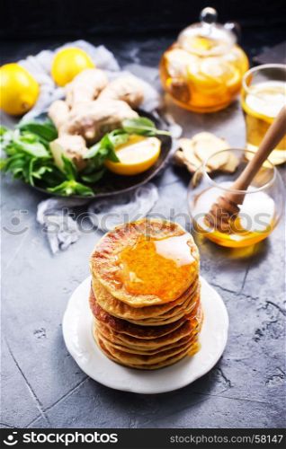 pancakes with honey on plate and on a table